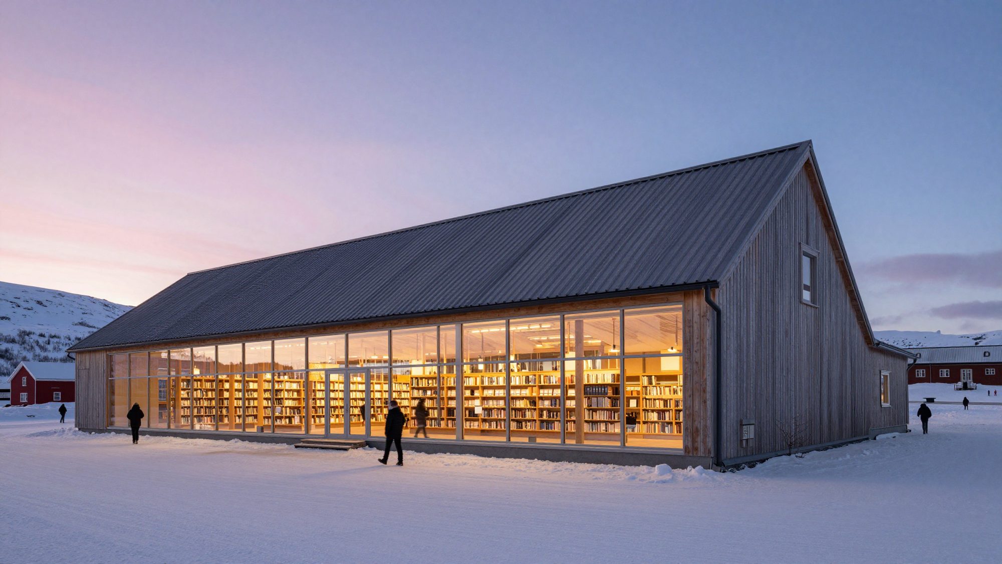 A long timber library with a folded roof and a glowing glass ground floor in the snow at dusk.